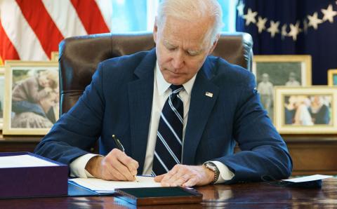 U.S. President Joe Biden signs the American Rescue Plan on Thursday in the Oval Office of the White House in Washington, D.C. (MANDEL NGAN/AFP/Getty Images/TNS)