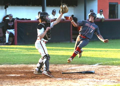 Fort White catcher Brad Sullivan (left) grabs a relay throw from right field but can’t apply the tag to a sliding Brantley Hengerer during the top of the third inning of the Indians’ 3-1 loss Monday night against Hilliard. (MORGAN MCMULLEN/Lake City Reporter)