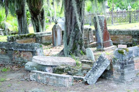 A family gravesite in Oaklawn Cemetery with an overturned tombstone, dilapidated brick wall and high grass is a common site at the local cemetery. (TONY BRITT/Lake City Reporter)