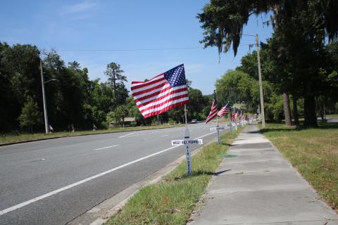 TONY BRITT/Lake City Reporter A row of flags — just several out of 114 — stand alongside State Road 47. Jack and Ann Hampton, along with a handful of volunteers, put them up on Saturday. (TONY BRITT/Lake City Reporter)