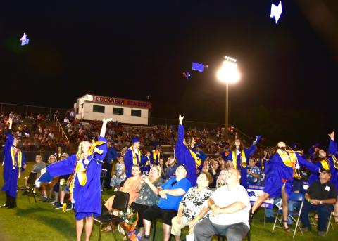 Branford High School graduates, sitting with friends and family, toss their caps into the air after their graduation ceremony at Buccaneer Stadium on Friday evening. (ROB WOLFE/Special to the Reporter) 