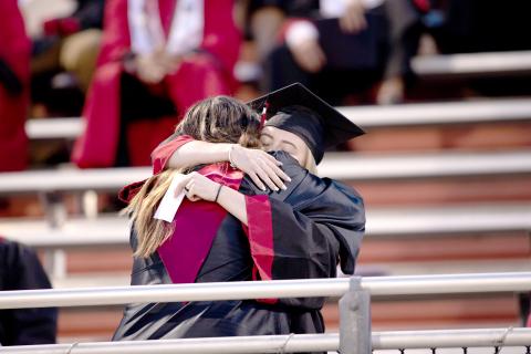 A Fort White High School graduate hugs one of her teachers Friday night during the commencement ceremony. (JACOB PRICE/Special to the Reporter)