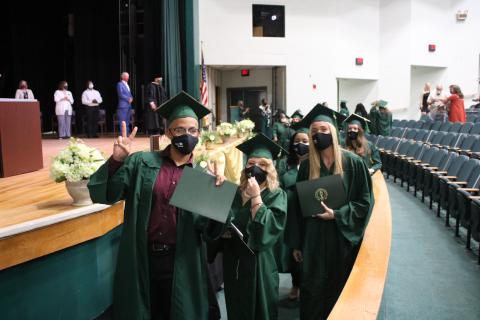 Andrey Brinson (from left), Brianna Thornton and Gabrielle Ann Gilliam pose for pictures as they exit their graduation ceremony with diplomas Tuesday afternoon at Florida Gateway College. (TONY BRITT/Lake City Reporter)