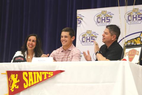 Columbia shortstop Mason Gray (middle) smiles after signing his letter of intent with Flagler alongside his mother, Heather, and father, Kevin, on Tuesday. (MORGAN MCMULLEN/Lake City Reporter)