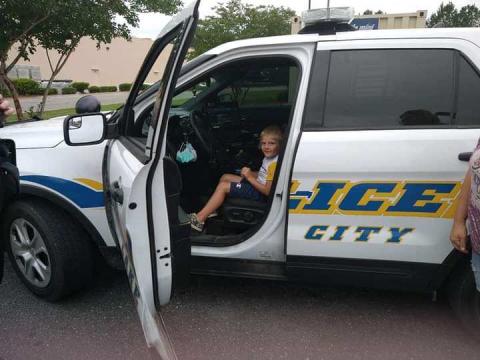 Five-year-old Wyatt Griffis sits in the patrol vehicle of Lake City police officer Michael Craig following an interaction between the two near a Dollar Tree store. (COURTESY)