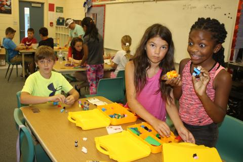 Columbia City Elementary students Jasom Chase (from left), Johanna Angelo and Cache Sheppard play with a set of Legos Wednesday morning. (TONY BRITT/Lake City Reporter)