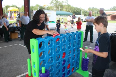 Jean Hamm (left) plays Connect Four with her grandson, Titan Turner, 9, during the Columbia County Sheriff’s Office Summer Nights event Friday night at Five Points Elementary School. (TONY BRITT/Lake City Reporter)