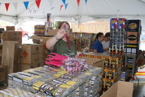 Kaleigh Clements, a Lake City Middle School student, arranges packs of bottle rockets Thursday at the CHS FFA Chapter TNT fireworks tent. Proceeds raised from the sales will be used to help fund the CHS FFA program. (TONY BRITT/Lake City Reporter)