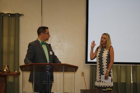 Lee Pinchouck (left), Rotary Club of Lake City immediate past president, reads the oath installing Meagan Logan as the club’s first female president Thursday. (TONY BRITT/Lake City Reporter)