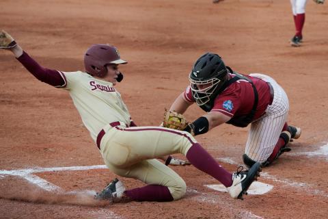 Florida State’s Dani Morgan, left, slides home safely as Alabama catcher Bailey Hemphill reaches in for the tag in the third inning of Monday’s Women’s College World Series semifinal game in Oklahoma City. (SUE OGROCKI/Associated Press)