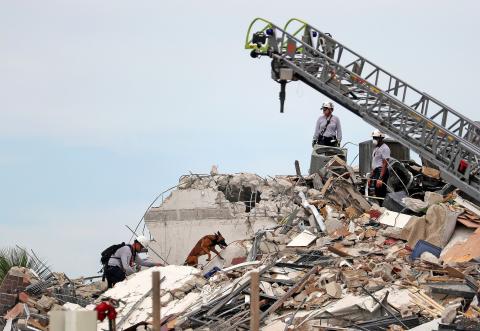 Search and Rescue workers along with K-9 units search the site of the 12-story oceanfront Champlain Towers South Condo, with more than 100 units at 8777 Collins Ave., that partially collapsed around 2 a.m. on Thursday, June 24, 2021 in Surfside. (MIKE STOCKER/South Florida Sun Sentinel/TNS)