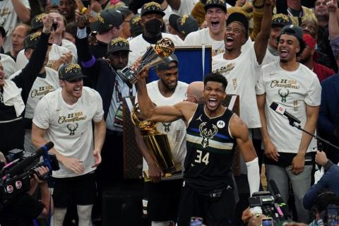 Milwaukee Bucks forward Giannis Antetokounmpo (34) reacts with the championship trophy after defeating the Phoenix Suns in Game 6 of the NBA Finals on Tuesday in Milwaukee. The Bucks won 105-98. (PAUL SANCYA/Associated Press)