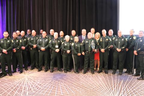 Sergeant Tim Ball (holding trophy) is joined by the 19 officers that make up the CCSO School Resource Unit Monday at the annual Florida Association of School Resource Officers conference. (COURTESY)