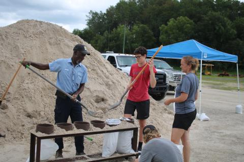 Neville Taylor (from left), a Columbia County Public Works employee, helps Micah Taber and Lisa Taber as they fill sandbags at the Columbia County Public Works Construction Yard Tuesday afternoon. (TONY BRITT/Lake City Reporter)