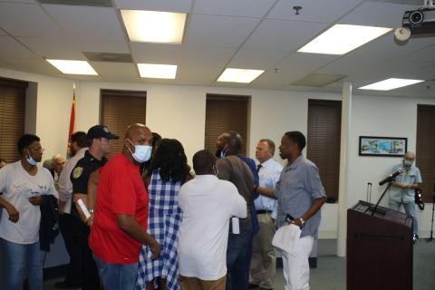 Conrad Wallace (foreground) and others attempt to restrain Sylvester Warren as he engages in a verbal confrontation with council member Eugene Jefferson. (TONY BRITT/Lake City Reporter)