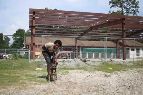 Jakwon Rhodes, a Lake City Humane Society employee, walks “Gunner” on the humane society campus Wednesday afternoon in front of the James Montgomery Animal Wellness Center Building, which has been under construction for weeks. (TONY BRITT/Lake City Reporter)