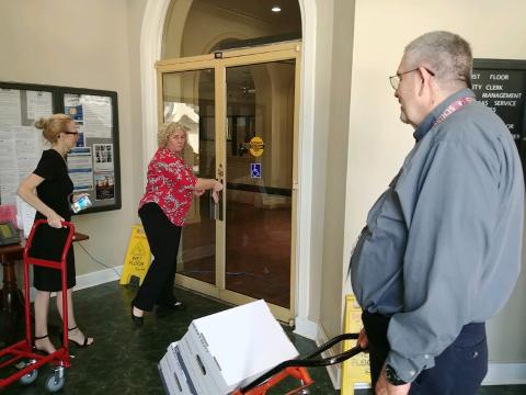 City Clerk Audrey Sikes (from left) and Records Coordinator Nikki Starling talk to Growth Management Director David Young as the three move boxes to their new temporary offices after mold was found on the first floor at city hall. (TONY BRITT/Lake City Reporter)