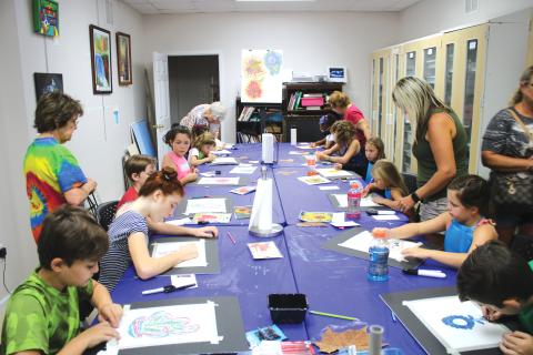 A group of students work on artwork Friday at the Gateway Art Gallery. Local artists served as instructors for the classes. (TONY BRITT/Lake City Reporter)