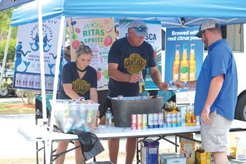 A pair of craft beer vendors deliver service to an attendee of the 2019 Gateway City Craft Beer & Wine Festival. (FILE)