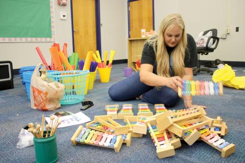 Dianna Swisher, the Columbia County School District’s volunteer and marketing coordinator, sorts through xylophones for Ginger Norris’s renovated music room at Fort White Elementary School. (TONY BRITT/Lake City Reporter)