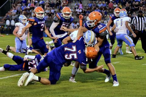 Branford defensive lineman Cole Certain (75) and linebacker Seth Humphries (28) make a tackle against Chiefland in the Preseason Classic on Aug. 20. (ROB WOLFE/Special to the Reporter)