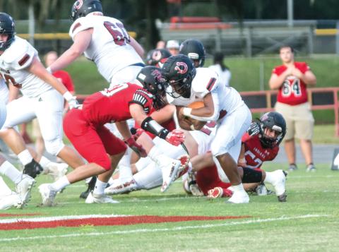Fort White linebacker Coby Lee (left) makes a tackle on a Middleburg ballcarrier Friday night at Arrowhead Stadium. (CHRISTINA FEAGIN/Lake City Reporter)