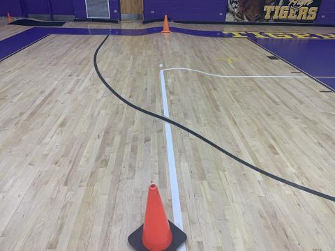 A stretch of Columbia’s gym floor is shown with a bump in it due to water damage. The school began tearing up the court on Tuesday to install a new one. (COURTESY)