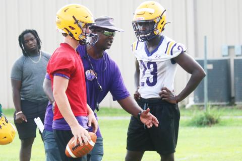 Columbia head coach Demetric Jackson (middle) instructs quarterback Kade Jackson (left) and running back Malik Moore (right) during practice on Monday. (JORDAN KROEGER/Lake City Reporter)