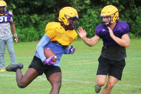 Columbia receiver Brae Deal runs up the field after a catch as linebacker Noah Morris rushes in to tag him during practice on Friday. (JORDAN KROEGER/Lake City Reporter)