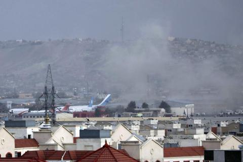 Smoke rises from a deadly explosion outside the airport in Kabul on Thursday. Two suicide bombers and gunmen targeted crowds massing near the Kabul airport. (WALI SABAWOON/Associated Press)