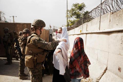 In this photo provided by the U.S. Marine Corps, two civilians during processing through an Evacuee Control Checkpoint during an evacuation at Hamid Karzai International Airport on Thursday in Kabul, Afghanistan. (STAFF SGT. VICTOR MANCILLA/U.S. Marine Corps via AP)