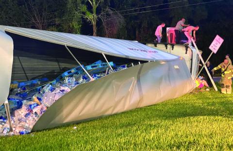 A tractor trailer hauling botted water overturned at the B&B Food Store on State Road 47 in Columbia City on Monday night. (JAMIE WACHTER/Lake City Reporter)