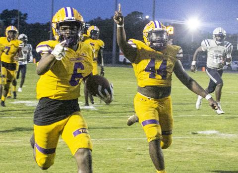 Columbia kick return Tray Tolliver points to the end zone as defensive end Bobby Miller celebrates alongside him during one of Tolliver's two punt returns for touchdowns against American Heritage-Delray on Friday night. (JEN CHASTEEN/Special to the Reporter)