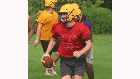 Columbia quarterbacks Kade Jackson looks down the field to throw as he escapes pressure from the defense during practice on Tuesday. (JORDAN KROEGER/Lake City Reporter)