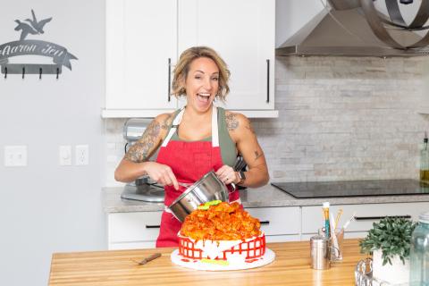Amy Strickland puts the finishing touches on a cake, decorated as a basket of hot wings. (BRENT KUYKENDALL/Lake City Reporter)