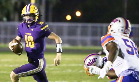 Columbia quarterback Kade Jackson scrambles away from pressure against Bolles on Friday night. (BRENT KUYKENDALL/Lake City Reporter)