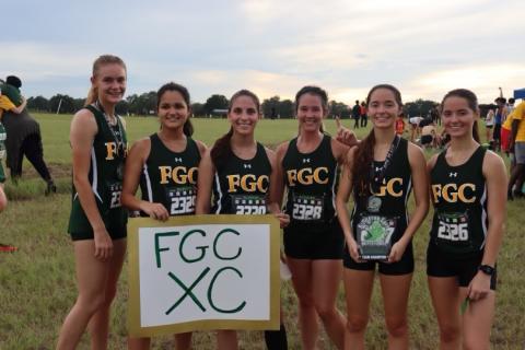 FGC runners Ariel Anderson (from left), Merlin Leal, Savana Thomas, Fallon Flynn, Kyla Desmartin (holding 1st place team trophy) and Kayla Desmartin are pictured after the Timberwolves won the 13th Annual Alligator Lake XC Invite on Friday. (COURTESY)