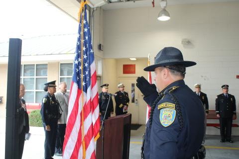 A Lake City police officer salutes the American flag Thursday at the start of the 9/11 memorial ceremony. (TONY BRITT/Lake City Reporter)