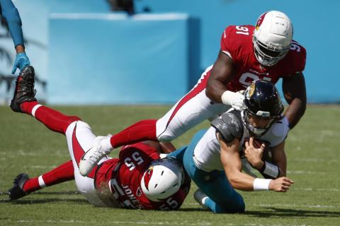 Arizona Cardinals linebacker Chandler Jones (55) and defensive end Michael Dogbe (91) tackle Jacksonville Jaguars quarterback Trevor Lawrence on Sept. 26 in Jacksonville. (STEPHEN B. MORTON/Associated Press)