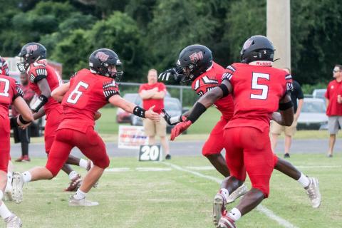 Fort White quarterback Clayton Philpot fakes a handoff to running back Darren Clark during their Preseason Classic against Middleburg on Aug. 20. (CHRISTINA FEAGIN/Special to the Reporter)