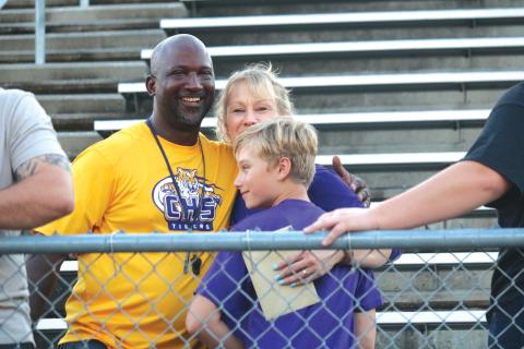 Columbia High School football head coach Demetric Jackson (left) hugs Crystal and Fisher Hair Wednesday afternoon at Tiger Stadium at a memorial service for Skipper Hair. (JORDAN KROEGER/Lake City Reporter)