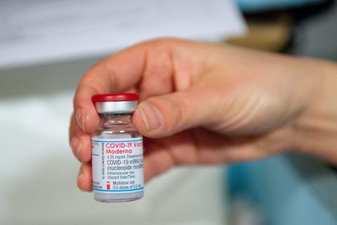A health care professional holds a vial of the Moderna covid-19 vaccine on April 7 in Carmarthen, Wales. (JACOB KING/POOL/AFP via Getty Images)