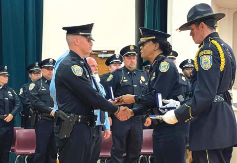Lake City Police Officer Remington ‘Cody’ Chauncey (left) accepts his Police Purple Heart, presented by Police Chief Argatha Gilmore, on Monday. (COURTESY)