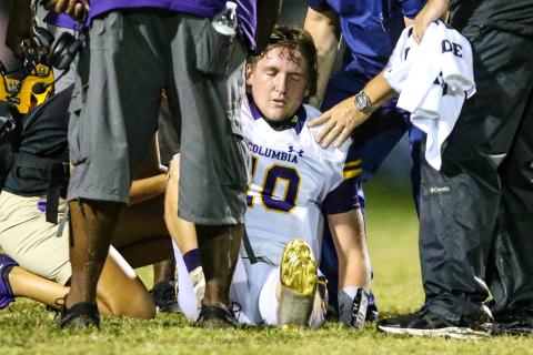 Columbia quarterback Kade Jackson is attended to by trainers after separating his shoulder during Friday’s game against Riverside. (GARY LLOYD MCCULLOUGH/Special to the Reporter)