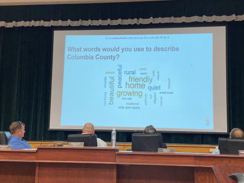 County Commissioners Tim Murphy (from left), Rocky Ford and Toby Witt look at a word cloud of residents’ descriptions of Columbia County. (JAMIE WACHTER/Lake City Reporter)