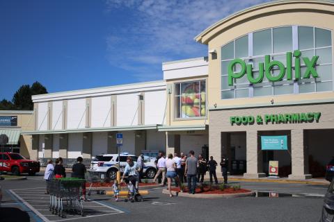 First responders hold potential customers outside at the Publix at 255 NW Commons Loop after a maintenance worker passed out and later died. (TONY BRITT/Lake City Reporter)