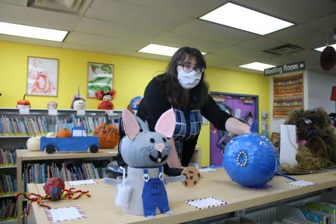 Emma Miles, Columbia County Public Library Youth Services Programs Specialist, aligns decorated pumpkins in the Youth Services Department at the main branch of the Columbia County Public Library on Tuesday afternoon. (TONY BRITT/Lake City Reporter)