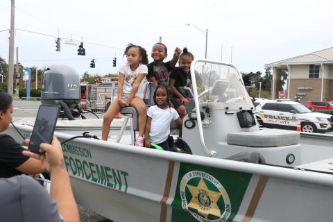 Lauryelle Broome (from left), Melissa Wright, Lavell Broome and Millicent Wright explore a Florida Fish and Wildlife Commission law enforcement boat Tuesday night at the National Night Out event in downtown Lake City. (MORGAN MCMULLEN/Lake City Reporter)