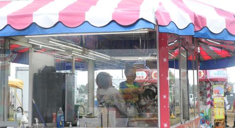 Hannah (left) and Faith Turner share a laugh as they set up a food trailer Thursday afternoon in preparation for opening night of the 67th annual Florida Gateway Fair. (MORGAN MCMULLEN/Lake City Reporter)