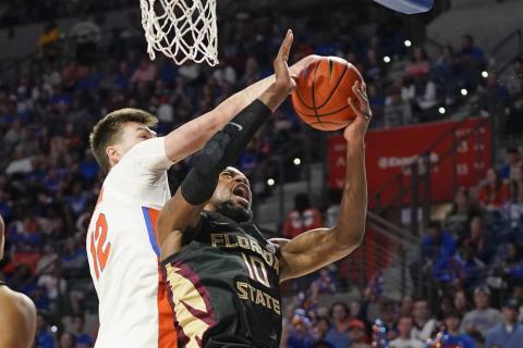 Florida forward Colin Castleton blocks a shot by Florida State forward Malik Osborne during Sunday’s game in Gainesville. (JOHN RAOUX/Associated Press)